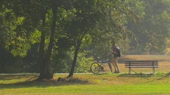 Man With Backpack is Standing at The Bench