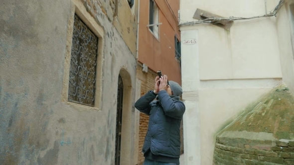 Man Filming Old Architecture With Retro Camera