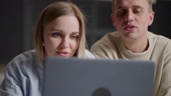 Bonding Millennial Smiling Couple Looking at Laptop Screen Choosing Goods in Online Store Involved