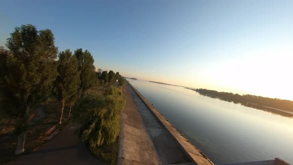 FPV Drone Flies Over the City Embankment at Dawn