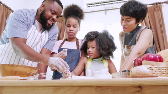 Two Kids and family preparing flour in kitchen at home.