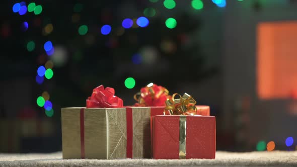 Three Warped X-Mas Presents on Floor, Lights Sparkling on Background, Holiday