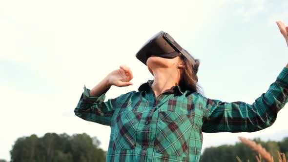 Girl in Virtual Reality Glasses Outdoors Among the Field. Future Technology Concept