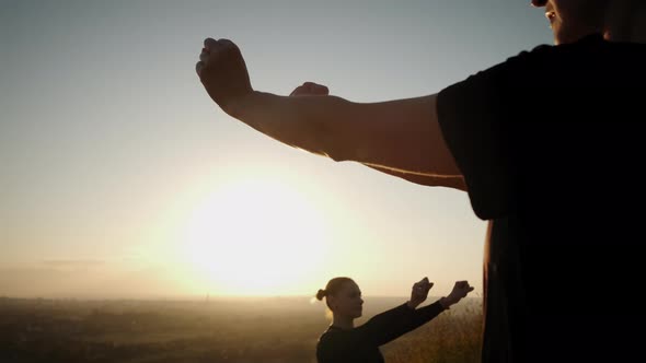 Against the Background of the Bright Orange Sunset Sky Group Woman's Practicing 