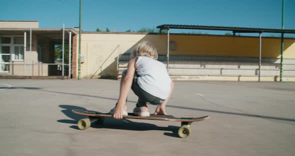 Children Ride on Skate Long Board at Sport Field on Summertime Vacation