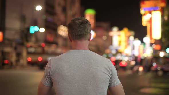 Rear View of Young Tourist Man Photographing the Streets of Chinatown at Night