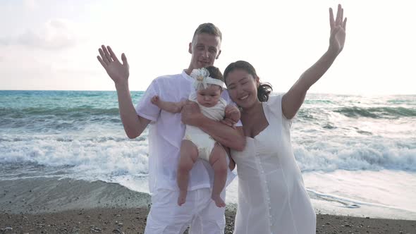 Happy Interracial Family Waving in Slow Motion Standing at Sunset on Beach with Turquoise