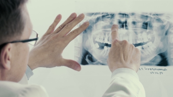 Male Doctor Analyzing X-ray In Clinic