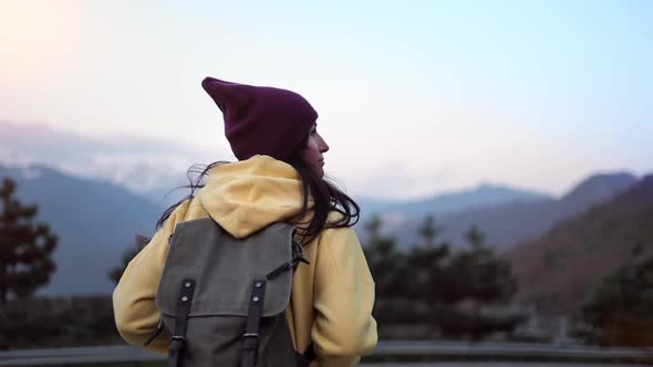 Active Travel Backpacker Woman Walking at Sunset Landscape Admiring Snow Mountain Peak Back View