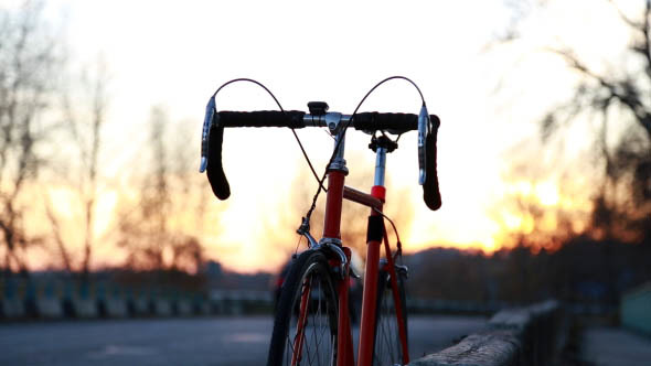 At Sunset, a Man Riding a Bicycle