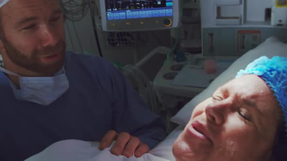 Close-up of Caucasian man comforting pregnant woman during labor in operation theater