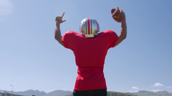 American football player standing with arms raised