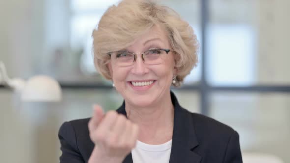 Portrait of Old Businesswoman Pointing and Inviting