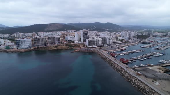 Densely populated town of Sant Antoni de Portman in Ibiza, Spain. Drone pull out shot.