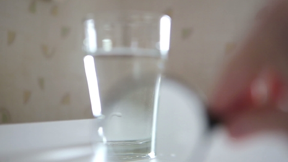 Glass Of Water Being Inspected With  Magnifying