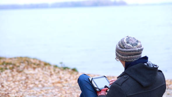 Man on the River Bank Using a Tablet
