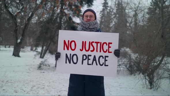 A Political activist is holding a sign No Justice No Peace in a strike action