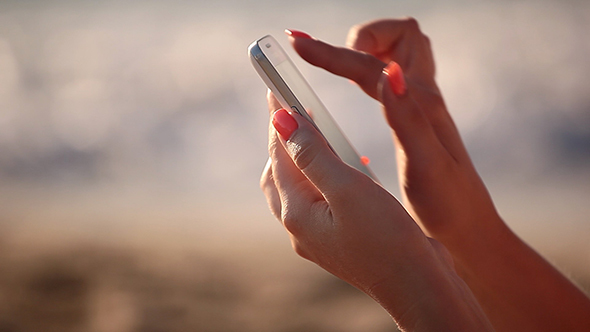 Using Smart Phone against Sea on Sunset