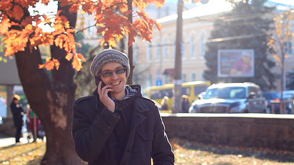 Young Man Talking On The Phone In The Park