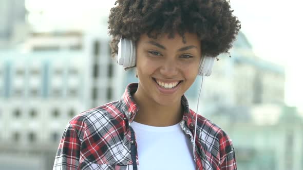 Cute African American Girl With Headset Looking Into Camera and Smiling, Joy