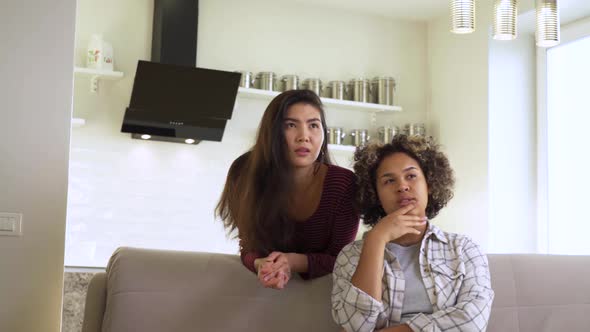 Two Girls Watch the News Intently