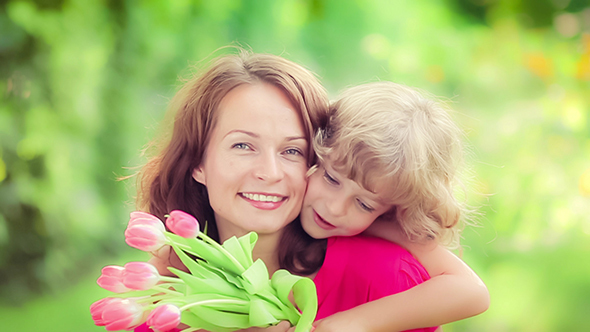 Beautiful Child Kissing Young Woman In Spring Park