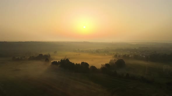 Aerial Landscape View of Sunny Morning Over Foggy Green Fields