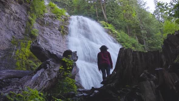 Woman Watching the Waterfall in the Canadian Rainforest