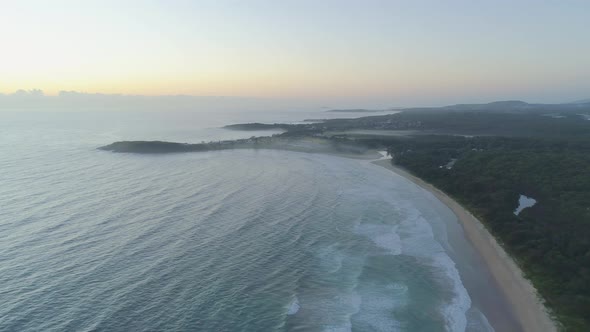 Forward flight over ocean toward Arrawarra Headland at sunset. New South Wales, Australia