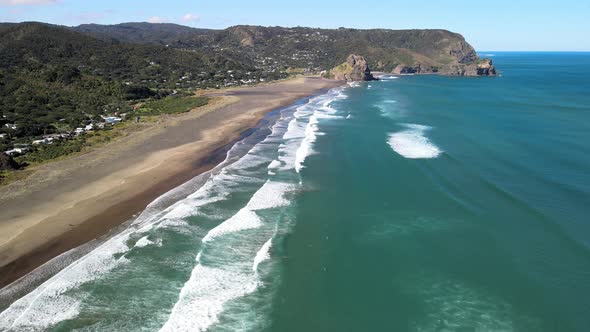 Flying down the famous Piha black sand beach in New Zealand at low tide