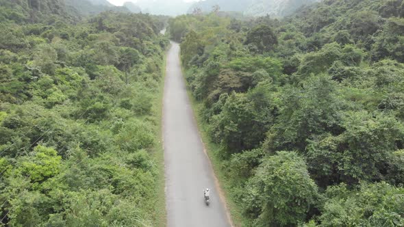 Aerial: one person riding scooter inland Cat Ba island, travel destination in Vietnam.