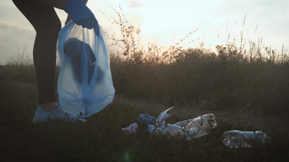 Care About Nature. Volunteer Girl Collects Trash in the Trash Bag. Trash-free Planet Concept. Nature