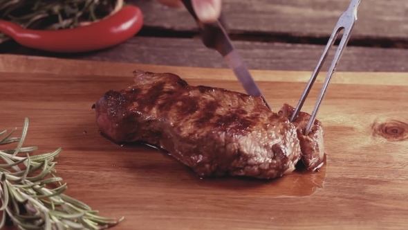 Slicing Of Grilled Steak On a Cutting Board