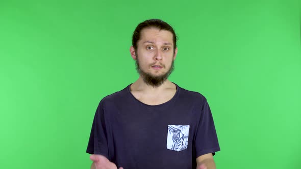 Portrait of a Young Man Talking and Pointing with His Hand at Something