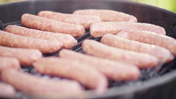 Slow Motion of Fresh Sausages Laid On a Smokey BBQ Grill