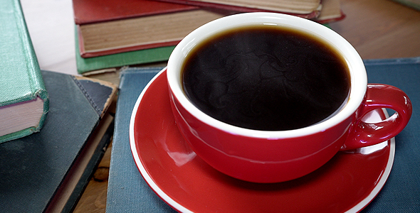 Hot Cup Of Black Coffee Stacked On Hardcover Book