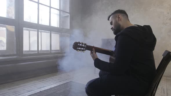 Young Man Playing Guitar in the Room