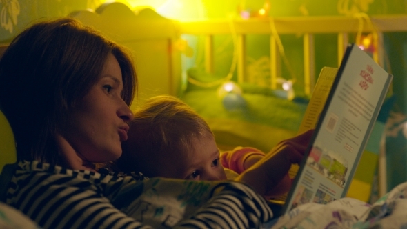 Mother Reading Bedtime Story To The Son