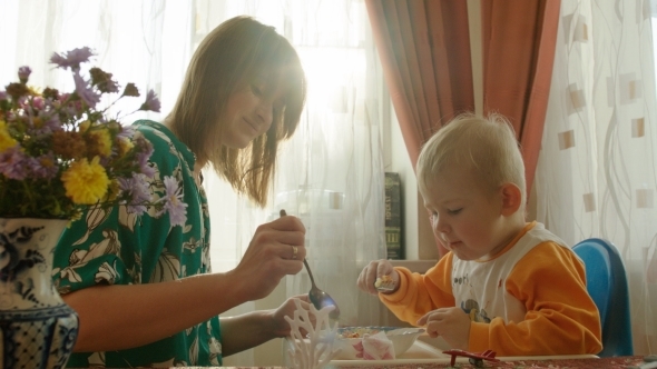 Mother Helping Her Son In Having Lunch