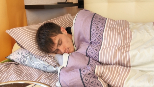 Young Man In Bed At Home Sleeping