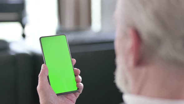 Rear View of Old Man Using Smartphone with Green Chroma Key Screen