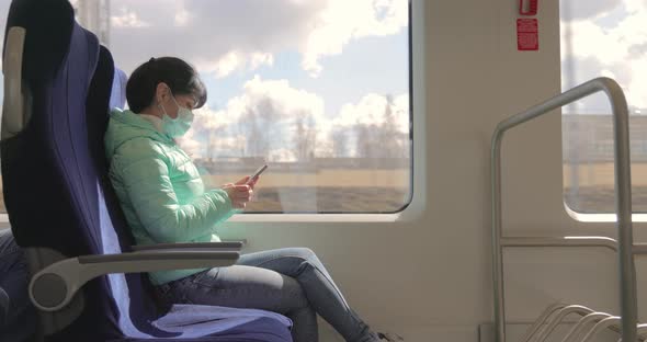 Woman Wearing a Protective Medical Face Mask Rides on a Train During the Covid 19 Quarantine