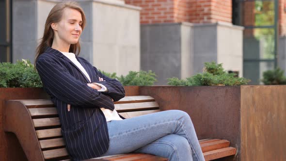 Serious Businesswoman Sitting Outside Office on Bench