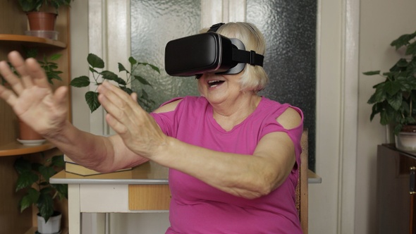 Senior Grandmother Woman in Virtual Headset Glasses Watching 3d Video in 360 Vr Helmet at Home