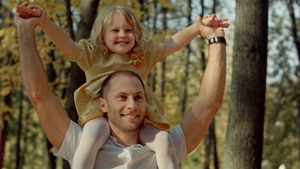 Little Girl Riding On Dads Neck At Autumn Park