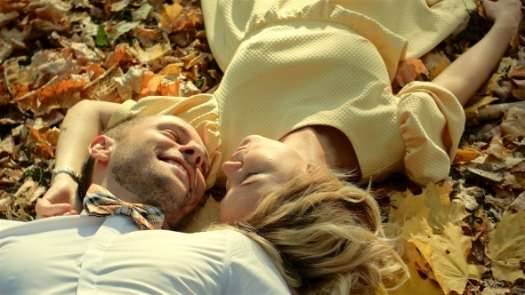 Smiling Couple Lying In Autumn Park