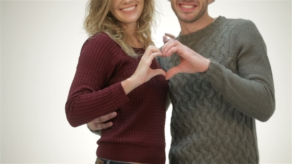 Young Couple Holding Hands In a Heart Shape