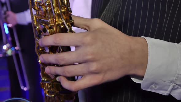 The Hands of a Teenager Playing on a Saxophone