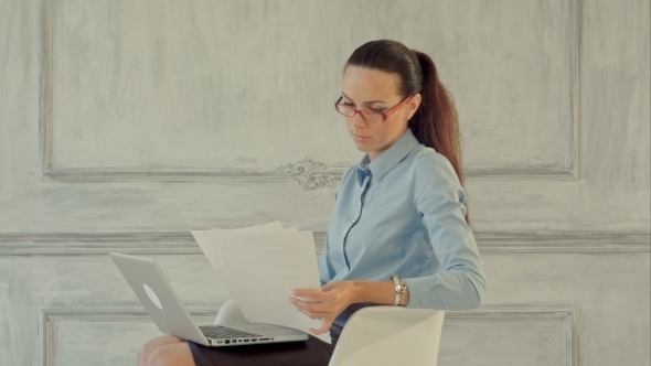 Attractive Businesswoman Reading Stats And Graphs