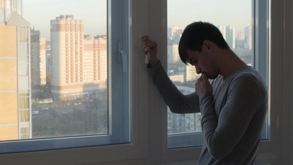 Worried Man Stand And Crying Near Window